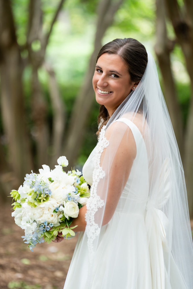 Elegant bridal portrait of Hannah framed by garden foliage in Dallas