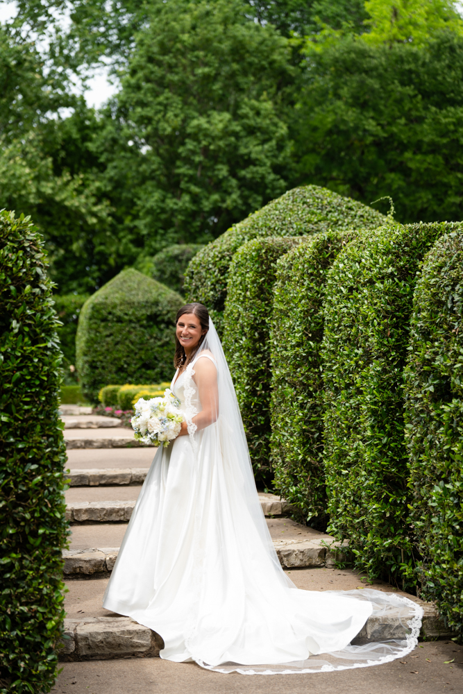 Bridal portrait of Hannah surrounded by lush greenery at the Dallas Arboretum