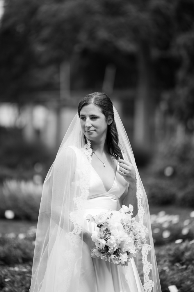 Hannah in her wedding gown beside blooming flowers at the Dallas Arboretum