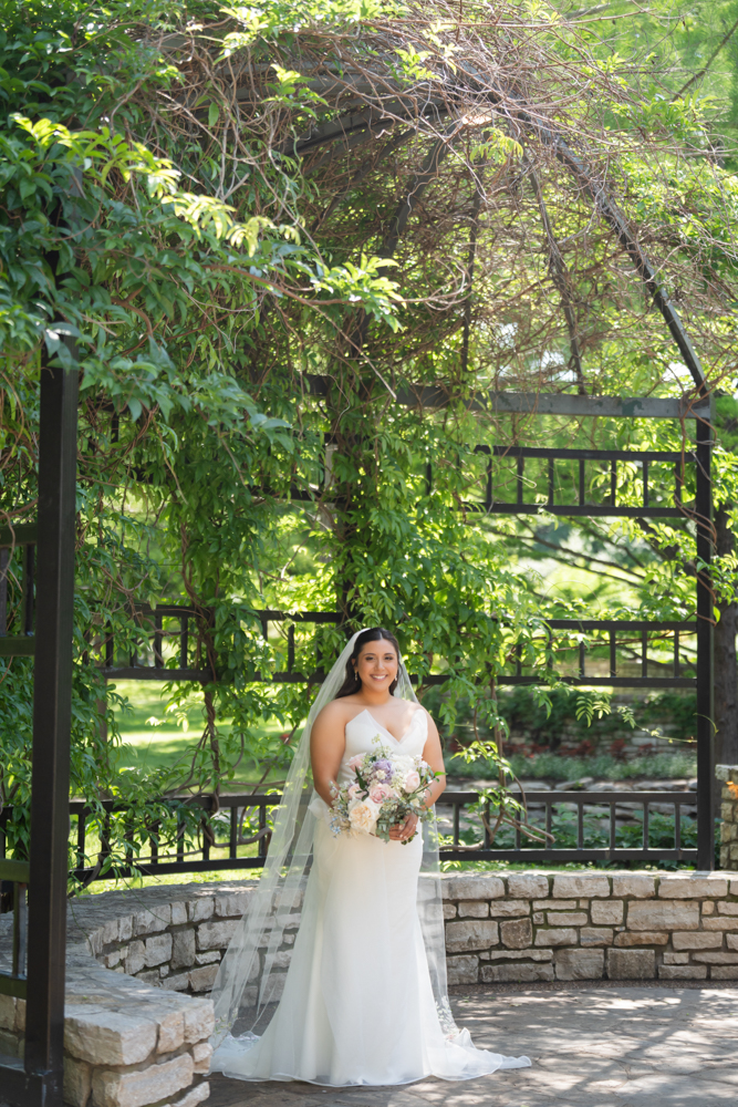 Caroline in her wedding gown among the greenery of the Fort Worth Botanic Garden