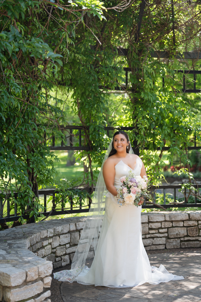 Bridal portrait of Caroline surrounded by lush garden foliage in Fort Worth