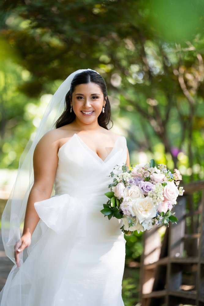 Bridal portrait of Caroline surrounded by lush garden foliage in Fort Worth