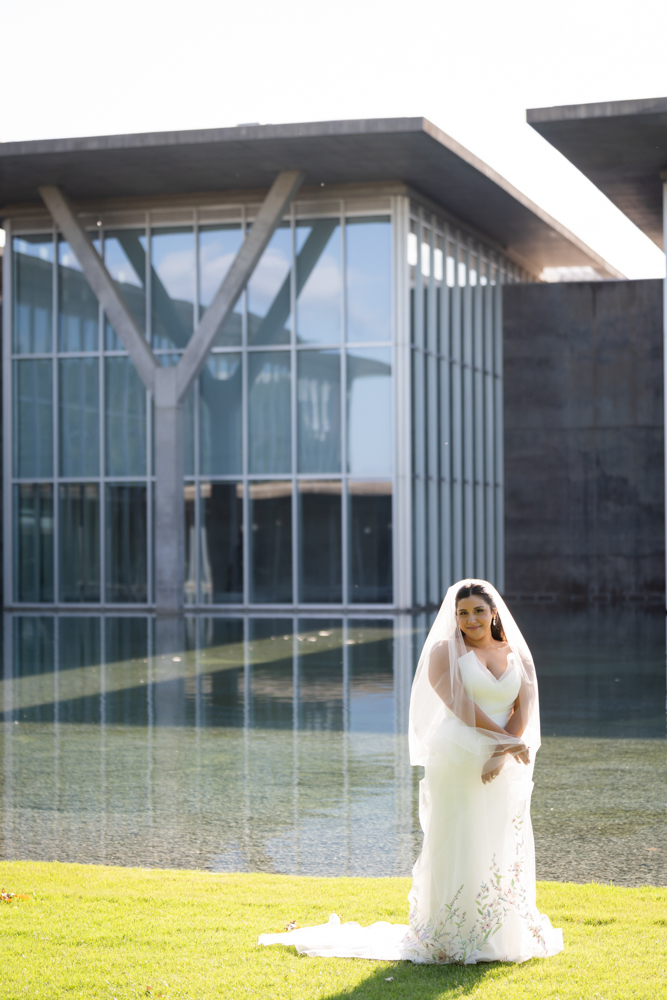 Bridal portrait of Caroline surrounded by lush garden foliage in Fort Worth