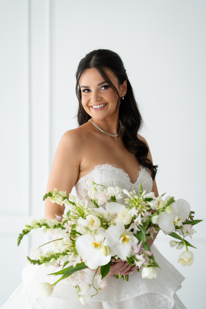 Hannah smiling in her wedding dress, a simple backdrop keeping the focus on the bride