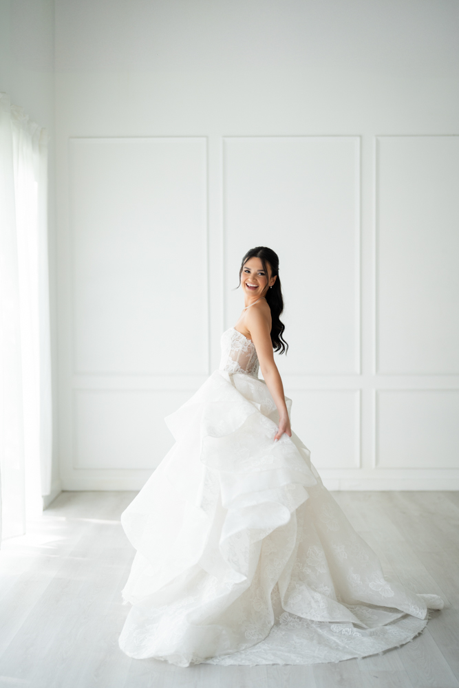 Portrait of Hannah beneath the false archway and draped fabric in the Fort Worth studio
