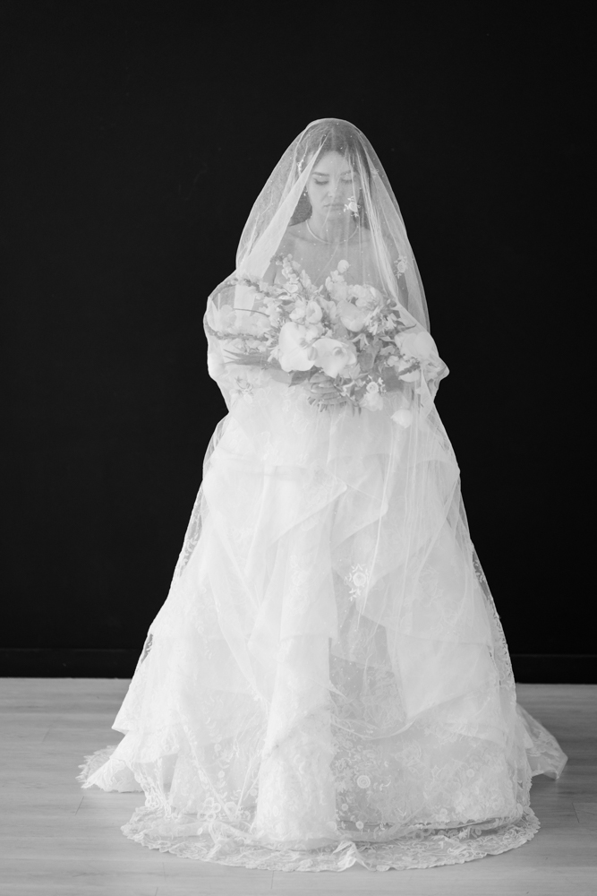 Hannah smiling in her wedding dress, a simple backdrop keeping the focus on the bride