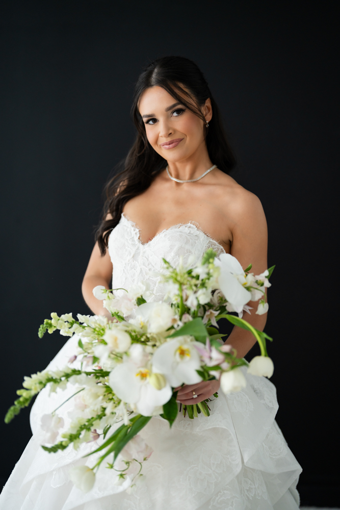 Close-up of the bodice and beadwork of Hannah's wedding gown in soft studio light