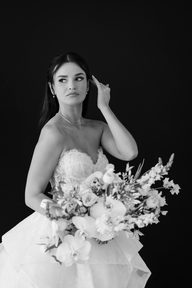 Seated bridal portrait of Hannah against a simple, uncluttered studio background