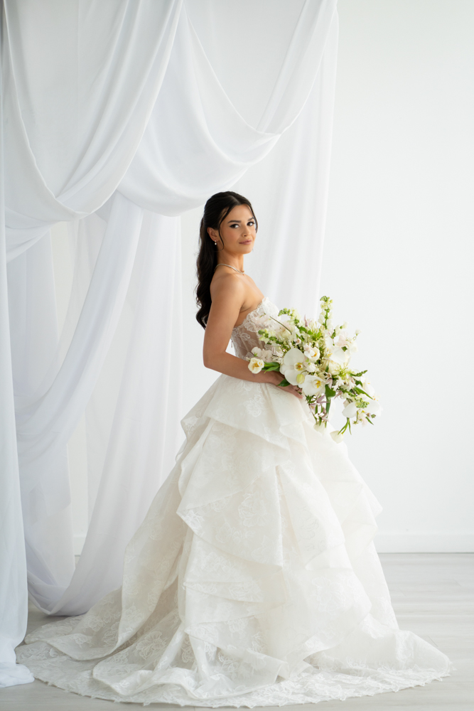Bride Hannah in her wedding gown against a clean studio backdrop at The Lumen Room in Fort Worth