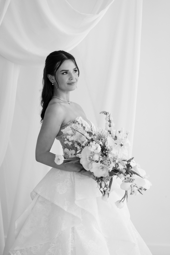 Full-length bridal portrait of Hannah, her gown pooling softly on the studio floor