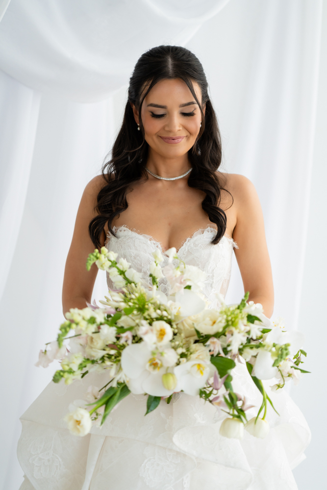 Seated bridal portrait of Hannah against a simple, uncluttered studio background