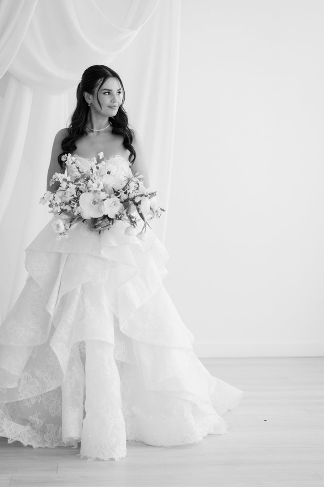 Hannah holding her bouquet as soft light falls across her gown