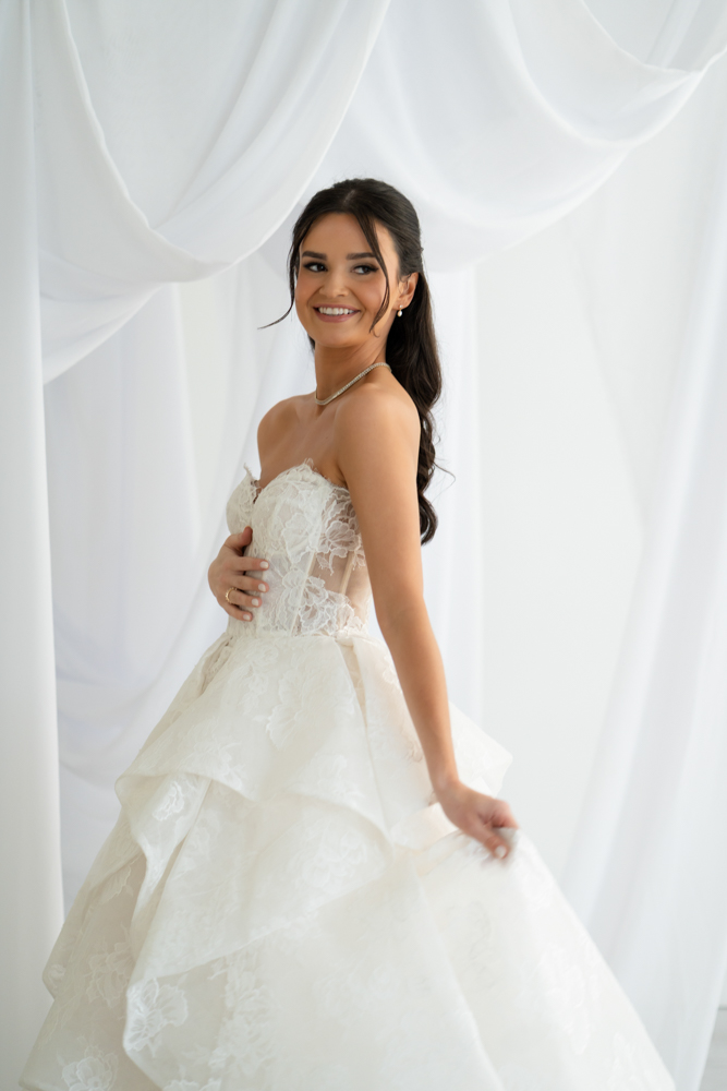 Hannah standing tall in her gown, the drapery gently framing the scene