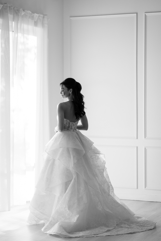 A quiet, intentional bridal pose with light shaping Hannah's face and gown