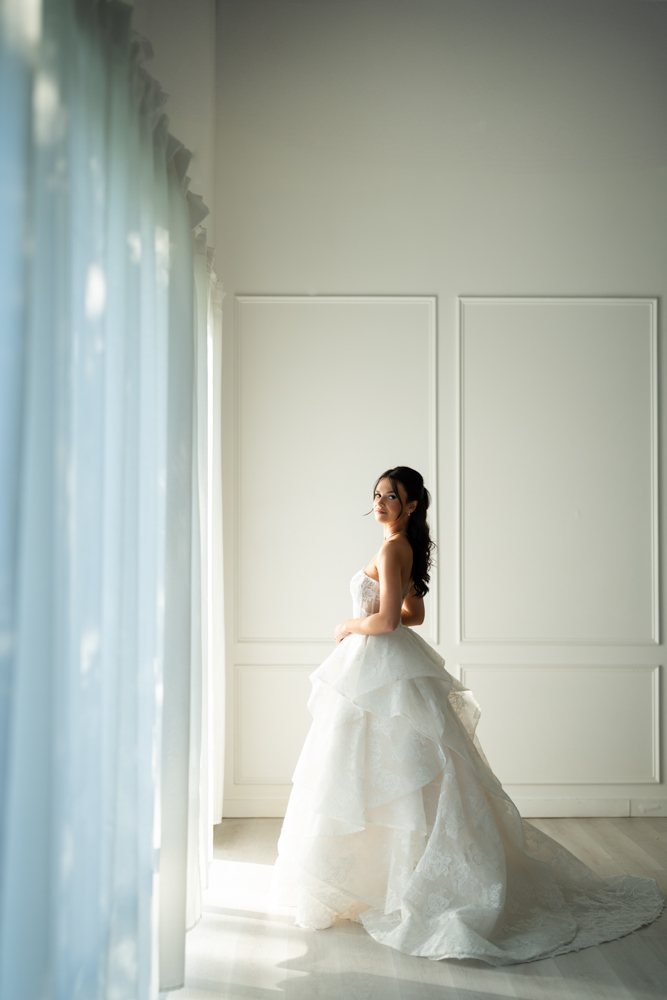 Hannah smiling in her wedding dress, a simple backdrop keeping the focus on the bride