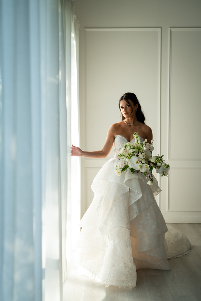 Seated bridal portrait of Hannah against a simple, uncluttered studio background