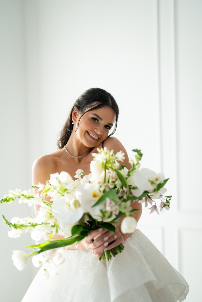 Hannah holding her bouquet as soft light falls across her gown