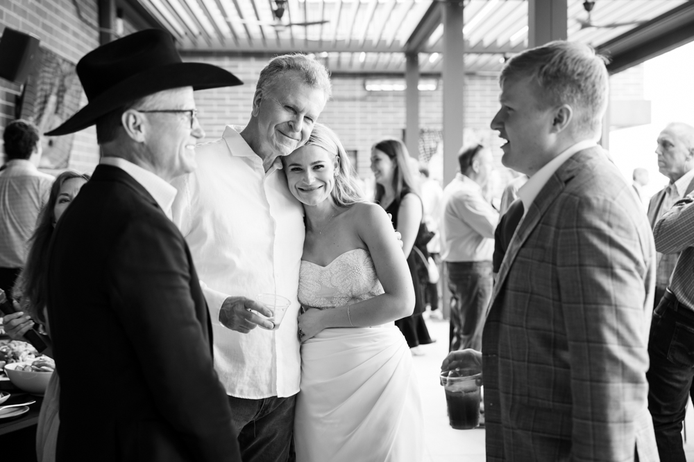 Cole sharing a laugh with friends at the rehearsal dinner