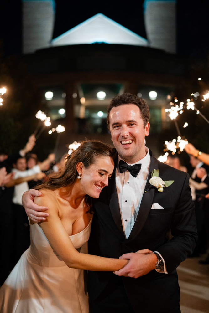 couple laughing and embracing during a sparkler exit at rivercrest country club wedding by tracy autem photography