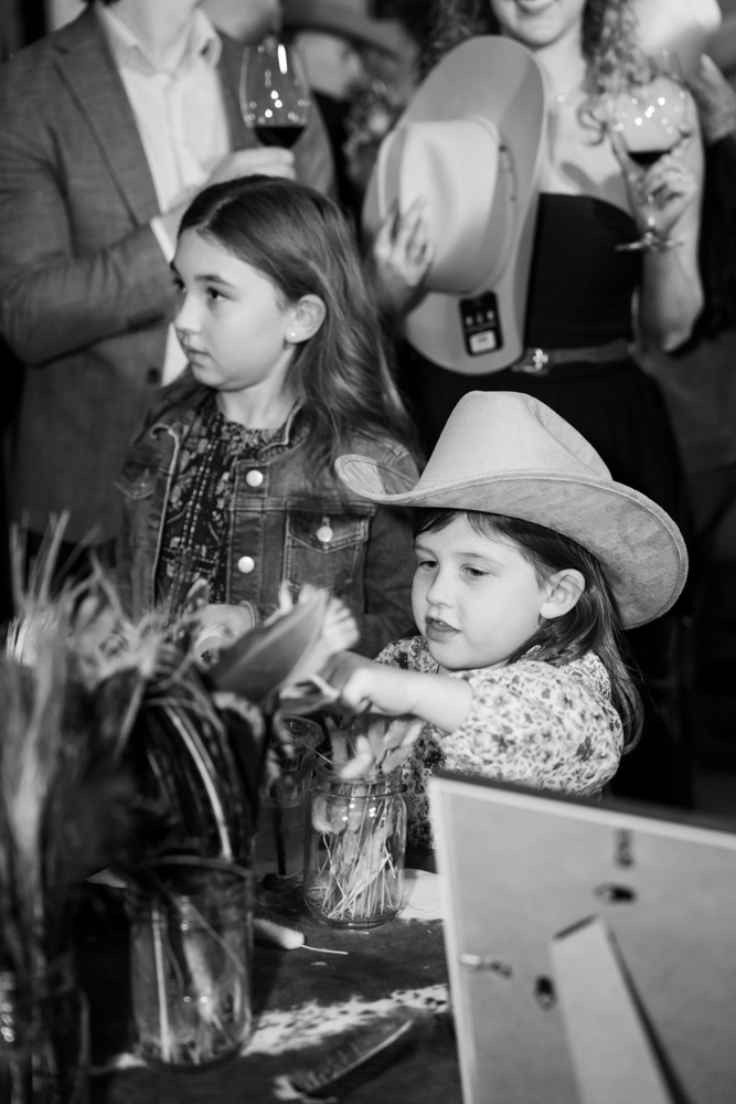 Guests mingling in custom cowboy hats at Clay Pigeon, Fort Worth